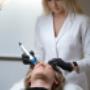 Zabieg mezoterapii mikroiglowej (dermapen) w MS Aesthetic Clinic. Specjalistka wykonuje zabieg na twarzy pacjentki.